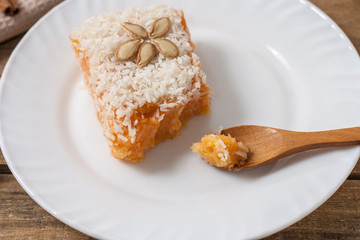 Slice of fresh homemade pumpkin pie and semolina on a white plate on a light background. . A Thanksgiving or holiday treat. Traditional autumn dish. Close up