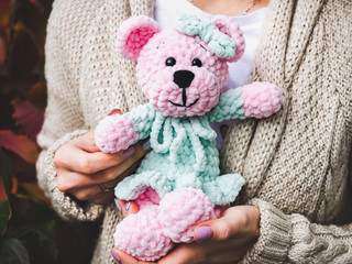 Pretty, young woman holding a stuffed toy in the background of yellow foliage. Close-up, outside