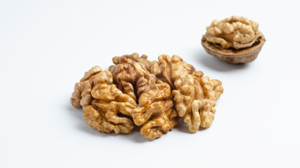 Handful of walnuts and half peeled walnut on an isolated background