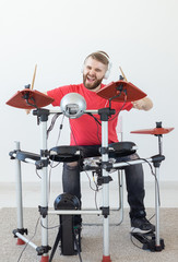 Fototapeta premium People, free time and hobby concept - bearded man drummer playing the drum.