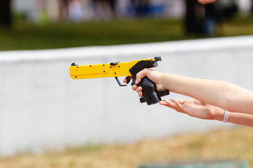 Hand with a yellow laser sport gun closeup