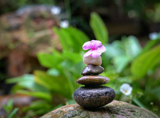 Stacked pebbles in the garden. Zen, spa or wellness concept.