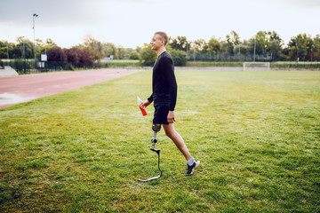 Full length of handsome fit caucasian handicapped sporty man in sportswear and with artificial leg...