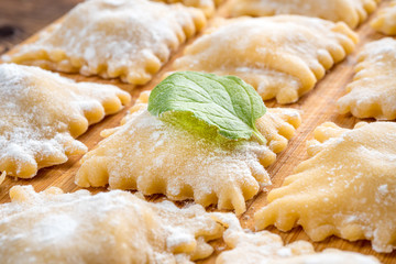 Close Up View of Fresh Homemade Ravioli With Green Basil Leaf. Soft focus.