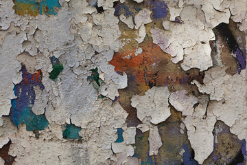 An old plastered wall with many layers of peeling colorful paint. Textures of old Moscow.