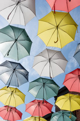 Fototapeta na wymiar Colorful umbrellas in the sunshine. Rue du Cul-de-Sac, in the Quartier Petit Champlain, in Quebec City