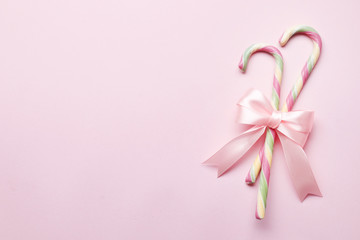 Creative minimal christmas art. The pattern is made with Christmas candies, bow on a bright pink background. The apartment was lying. Space for copy. Minimum composition.