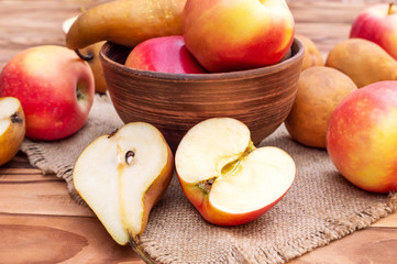 Bowl with apples and pears on wooden table. Fruit harvest. Healthy eating.