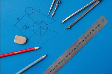 drawing a plan on a color surface using the pencil, ruler, compass and other tools, geometry shapes