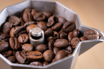 Coffee beans in an italian espresso coffee pot. Morning coffee and relaxing time. Macro shot.