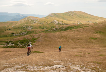 Fototapeta na wymiar two male bikers riding the bicycles in the mountain, summer active hiking