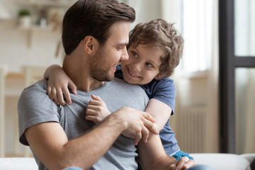 Cute little son hugging happy father, enjoying tender moment