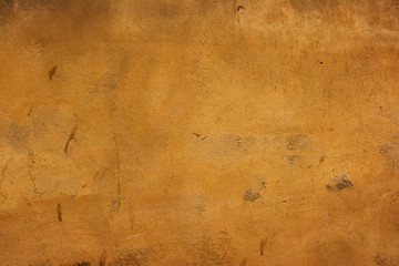 The surface of the old concrete wall painted in dark orange