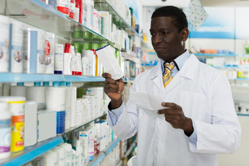  pharmacist looking at prescription and searching drug