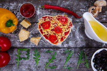 Heart shaped pizza ingredients. The name of the pizza is written in arugula.