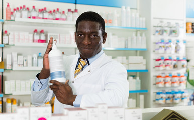 Portrait of experienced male pharmacist counseling about medicines in pharmacy