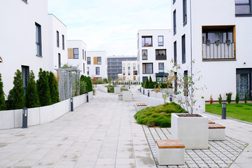 Sidewalk in a cozy courtyard of modern apartment buildings condo with white walls.