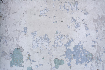 Light blue old concrete wall with partially peeling paint