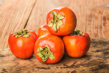 Delicious fresh persimmon fruit on wooden table.