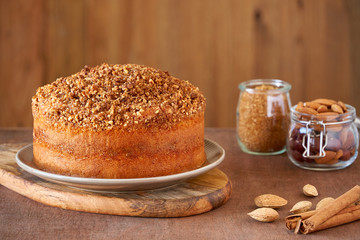  Almond cinnamon cake with ingredients on wooden table. Close up       