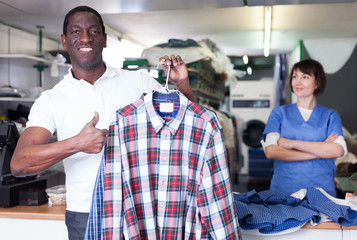 Happy man holding clean shirts