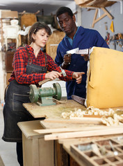 Carpenters inspecting old wooden chair