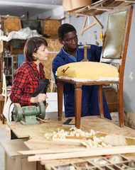 Restorers working with vintage armchair