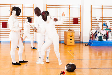 fencer practicing movements with african american trainer