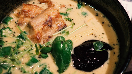Close-up images of yellow color soup curry with chicken, pork and vegetable in bowl which famous traditional food menu and only found in Hokkaido Sapporo district of Japan 