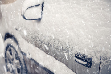 Cars covered by snow on street in winter day