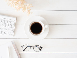 top view of office desk table with coffee cup and notebook on white background, graphic designer, Creative Designer concept.