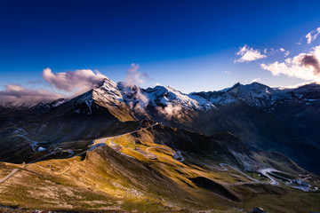 Panoramic View Over High Alpine Road and Snowy Mountains Peaks - obrazy, fototapety, plakaty