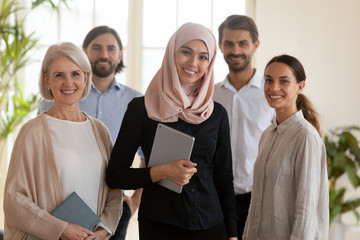 Confident happy asian muslim businesswoman manager and multicultural team portrait