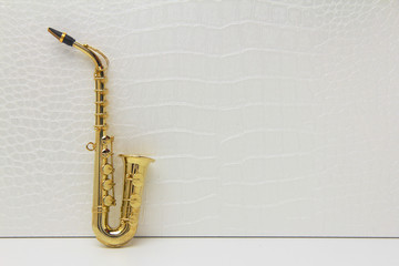 Naklejka premium gold saxophone on a background of crocodile skin wall