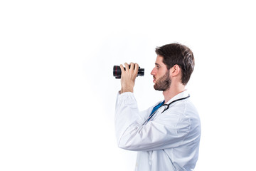 Medico con binocolo e stetoscopio sta cercando la terapia giusta. Sfondo bianco