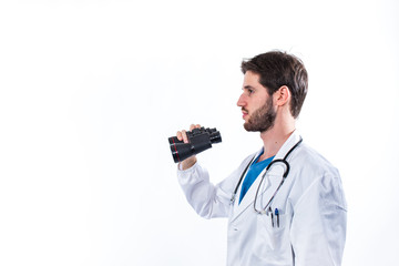 Medico con binocolo e stetoscopio sta cercando la terapia giusta. Sfondo bianco