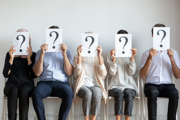 Unemployed businesspeople hiding face with questions waiting for job interview