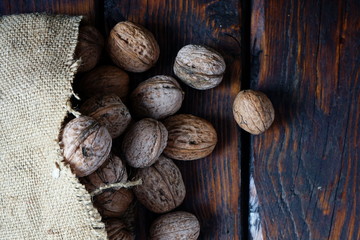 Walnuts spilled out of the bag onto the dark wooden table