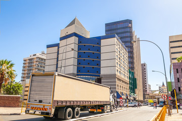 Obraz premium Windhoek downtown city center view with shopping mall, office buildings and road with truck and cars, Windhoek, Namibia