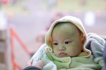 Close-up of asian baby boy wearing a Ivory sweater in dad's arms