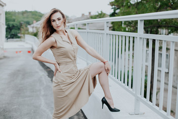 beautiful fashionable woman in a beige dress in the park on a walk