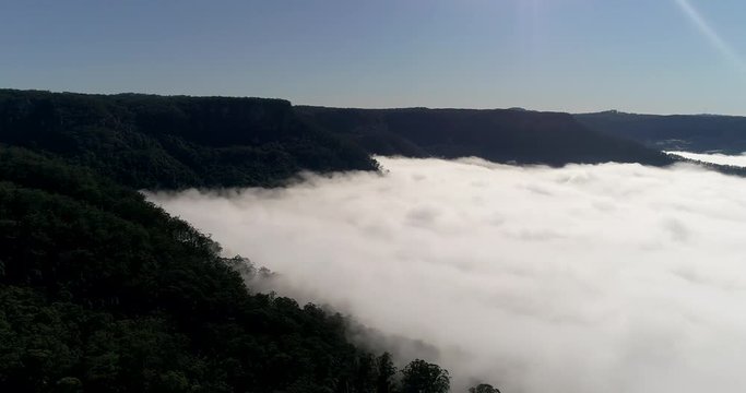 White thick clods hiding grounds of Kangaroo valley between sandstone ranges in aerial hovering between vale nature walls.