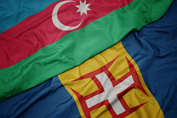 waving colorful flag of madeira and national flag of azerbaijan.