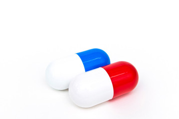 Big blue and red capsules on the white background. The concept of pharmaceutical treatment
