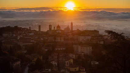 Bergamo, one of the most beautiful city in Italy. Amazing landscape of the old town and the fog covers the plain at sunrise. Fall season