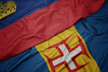waving colorful flag of madeira and national flag of liechtenstein.