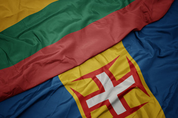 waving colorful flag of madeira and national flag of lithuania.