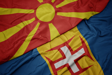 waving colorful flag of madeira and national flag of macedonia.