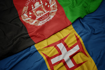 waving colorful flag of madeira and national flag of afghanistan.