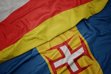 waving colorful flag of madeira and national flag of south ossetia.